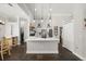 Modern, bright, white kitchen featuring an island with a sink, pendant lighting, and stainless steel appliances at 28924 Discovery Rd, Tavares, FL 32778