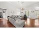 Bright living room boasts hardwood floors, a cozy gray couch, a wall clock, and a view to the outdoor patio at 28924 Discovery Rd, Tavares, FL 32778