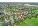 Wide aerial view of a golf community, showcasing home and nearby lake at 2954 Cedar Grove Loop, The Villages, FL 32163