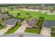 Aerial view of a single-story home with mature landscaping, a brick driveway, and a golf course view at 2954 Cedar Grove Loop, The Villages, FL 32163