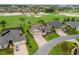 Aerial view of a house on a golf course with mature landscaping, and a patterned brick driveway at 2954 Cedar Grove Loop, The Villages, FL 32163