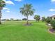 Beautiful backyard featuring manicured landscaping, lush lawn, and golf course views at 2954 Cedar Grove Loop, The Villages, FL 32163