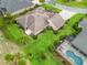 Backyard aerial view of a home showcasing lush landscaping and a screened in pool at 2954 Cedar Grove Loop, The Villages, FL 32163