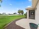 A view of the backyard with golf course and watering system beyond a patio at 2954 Cedar Grove Loop, The Villages, FL 32163