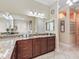 Elegant bathroom featuring a granite countertop vanity and an oversized mirror with decorative lighting at 2954 Cedar Grove Loop, The Villages, FL 32163