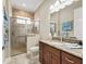 Bright bathroom features a tiled walk-in shower with glass doors, and a granite vanity at 2954 Cedar Grove Loop, The Villages, FL 32163