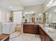 Bright bathroom featuring a walk-in tub, granite countertops, and a large mirror over the dual sinks at 2954 Cedar Grove Loop, The Villages, FL 32163