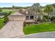 Well-maintained single-story home with a three-car garage, mature landscaping, and a patterned brick driveway at 2954 Cedar Grove Loop, The Villages, FL 32163