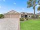 Charming home featuring a 3 car garage, brick driveway, manicured lawn and mature landscaping at 2954 Cedar Grove Loop, The Villages, FL 32163