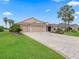 Charming single-story home with a three-car garage, a brick driveway, and mature landscaping at 2954 Cedar Grove Loop, The Villages, FL 32163