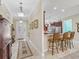 Elegant foyer with tiled floors, detailed trim, and an open view of the kitchen with barstool seating at 2954 Cedar Grove Loop, The Villages, FL 32163