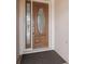 Elegant wood front door with decorative glass and a sidelight, providing a warm welcome at 2954 Cedar Grove Loop, The Villages, FL 32163
