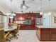Modern kitchen with stainless steel appliances, dark wood cabinets, granite counters, and an adjacent dining area at 2954 Cedar Grove Loop, The Villages, FL 32163