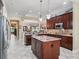 A spacious kitchen featuring dark wood cabinets, granite countertops, and stainless steel appliances at 2954 Cedar Grove Loop, The Villages, FL 32163