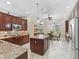 Well-equipped kitchen featuring granite countertops, dark wood cabinetry, stainless steel appliances, and a center island at 2954 Cedar Grove Loop, The Villages, FL 32163