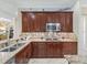Kitchen showcasing granite countertops, stainless steel appliances, dark cabinetry, and decorative tile backsplash at 2954 Cedar Grove Loop, The Villages, FL 32163