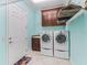 Convenient laundry room features modern appliances and ample cabinet storage at 2954 Cedar Grove Loop, The Villages, FL 32163