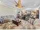 Inviting living room with comfortable seating, decorative ceiling fan, and stylish floral area rug at 2954 Cedar Grove Loop, The Villages, FL 32163