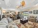 Open concept living room with striped sofas, ceiling fans and a view of the golf course at 2954 Cedar Grove Loop, The Villages, FL 32163