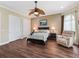 Main bedroom with hardwood floors, a ceiling fan, and a cozy seating area at 2954 Cedar Grove Loop, The Villages, FL 32163