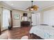 Well-lit main bedroom with hardwood floors, a ceiling fan, and a large dresser at 2954 Cedar Grove Loop, The Villages, FL 32163