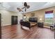 Spacious main bedroom showcasing hardwood floors, tray ceiling, and a view of the green outdoors at 2954 Cedar Grove Loop, The Villages, FL 32163