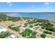 An aerial view of a neighborhood showcasing the homes, mature trees, and proximity to the water and open space at 307 Water Shore Dr, Leesburg, FL 34748