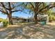 Expansive backyard featuring mature trees, screened pool, and home at 307 Water Shore Dr, Leesburg, FL 34748