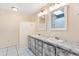 Bright bathroom with a double vanity, marble-look countertop, and dual mirrors at 307 Water Shore Dr, Leesburg, FL 34748