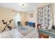 Versatile bonus room with a desk, exercise bike, rug, and bright natural light at 307 Water Shore Dr, Leesburg, FL 34748