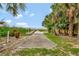 A concrete walkway leads to a private wooden dock with a serene view of the water and a blue sky at 307 Water Shore Dr, Leesburg, FL 34748