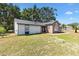 Quaint home featuring a brick facade with an arched window, surrounded by a lush, green lawn at 307 Water Shore Dr, Leesburg, FL 34748