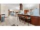 Open kitchen with wood cabinets, island seating, white appliances, and access to the living area at 307 Water Shore Dr, Leesburg, FL 34748
