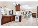 Open kitchen layout with white appliances, wood cabinets, island seating, and easy access to the living area at 307 Water Shore Dr, Leesburg, FL 34748