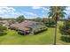 Aerial view showcasing a home with a pool, screened lanai, mature trees, and lush lawn in a serene neighborhood at 3319 Barrington Ct, The Villages, FL 32162