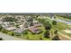 An aerial view of a residential community with golf course and a tranquil pond, showcasing manicured lawns at 3319 Barrington Ct, The Villages, FL 32162