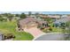 Aerial view showcasing a well-maintained single-story home with a two-car garage, brick driveway, and lush landscaping at 3319 Barrington Ct, The Villages, FL 32162