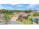 Aerial view showcasing a well-maintained single-story home with a two-car garage, brick driveway, and lush landscaping at 3319 Barrington Ct, The Villages, FL 32162