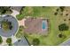Aerial view of a single-story home featuring a private screened-in pool, well-maintained landscaping and brick driveway at 3319 Barrington Ct, The Villages, FL 32162