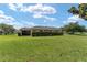 Lush backyard featuring a screened-in lanai and mature landscaping, perfect for outdoor enjoyment at 3319 Barrington Ct, The Villages, FL 32162