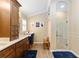 Bathroom featuring double vanity, dark wood cabinetry, stand up shower, and vinyl flooring at 3319 Barrington Ct, The Villages, FL 32162