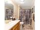 Cozy bathroom with a shower, vanity, and soft patterned shower curtain, offering practical comfort at 3319 Barrington Ct, The Villages, FL 32162