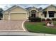 Charming single-story home boasts a two-car garage and a brick-paved driveway, complemented by lush landscaping at 3319 Barrington Ct, The Villages, FL 32162