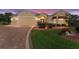 Inviting single-story home featuring a well-manicured lawn and a brick-paved driveway leading to a two-car garage at 3319 Barrington Ct, The Villages, FL 32162