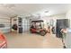 Attached garage featuring a golf cart, storage racks, and epoxy flooring, ideal for hobbyists at 3319 Barrington Ct, The Villages, FL 32162