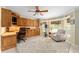 Bright home office featuring custom wooden built-ins, a cozy seating area, and a ceiling fan at 3319 Barrington Ct, The Villages, FL 32162