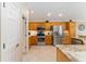 Spacious kitchen features stainless steel appliances, tile flooring, and light wood cabinets at 3319 Barrington Ct, The Villages, FL 32162