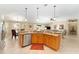 Open floorplan featuring kitchen with granite island, stainless dishwasher, and light wood cabinetry at 3319 Barrington Ct, The Villages, FL 32162