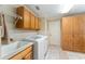 Well-equipped laundry room with a sink, modern washer and dryer, and ample cabinet space for storage at 3319 Barrington Ct, The Villages, FL 32162