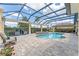 Expansive screened-in pool with spa, waterfall feature, BBQ grill, and outdoor lounge area at 3319 Barrington Ct, The Villages, FL 32162